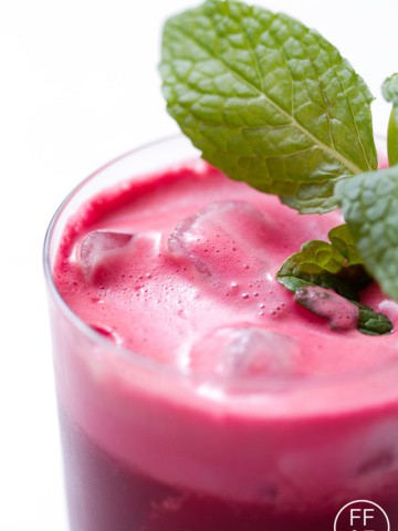 close up of beet juice garnished with mint sprig
