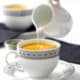 pouring cream into cup of soup with text instant pot carrot ginger soup