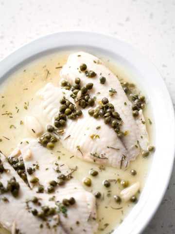 fish fillets on serving platter with capers and sauce