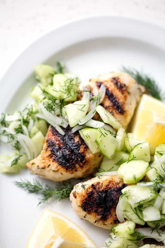 Grilled chicken with Cucumber Dill Salad on white background