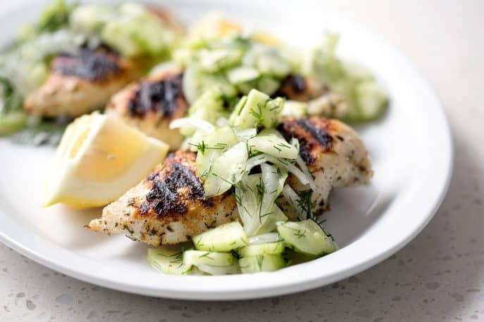 grilled chicken with cucumber salad on white background