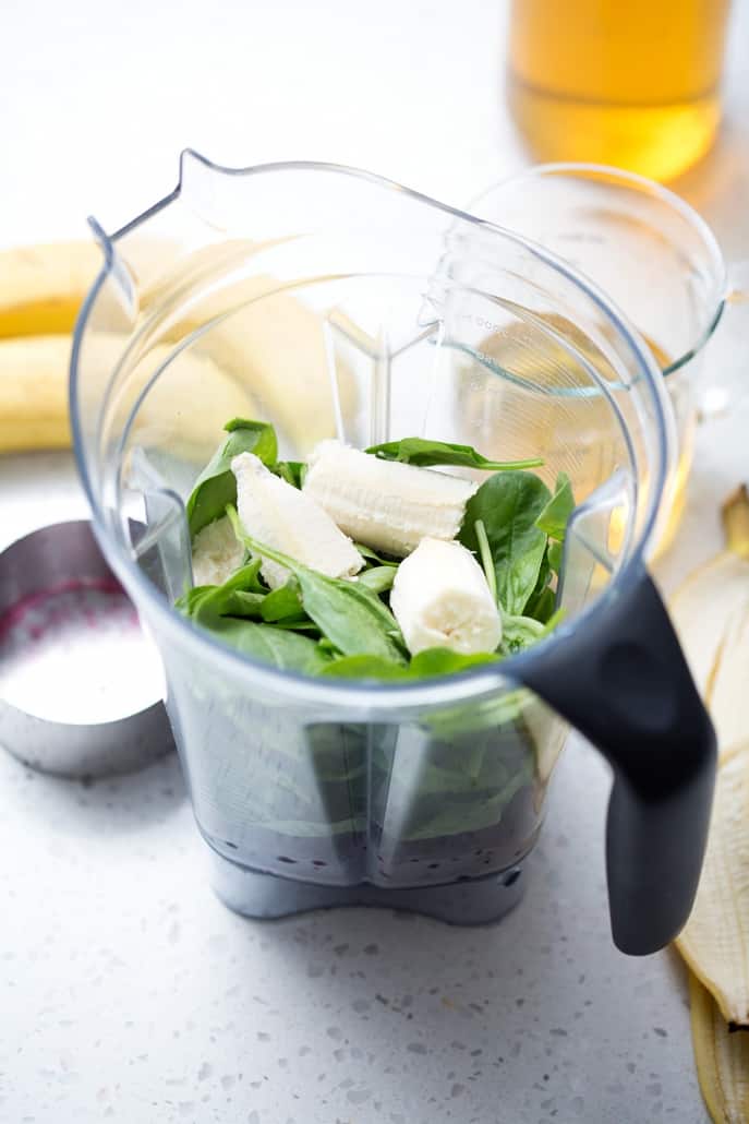 high speed blender filled with spinach and bananas