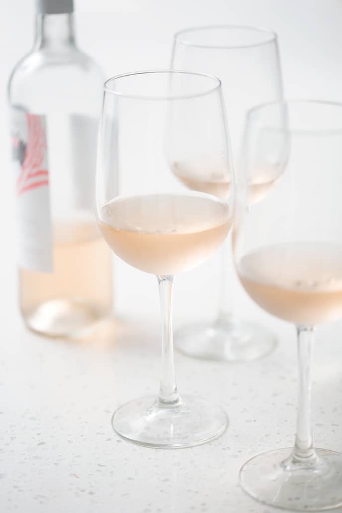 bottle of rose surrounded by glasses