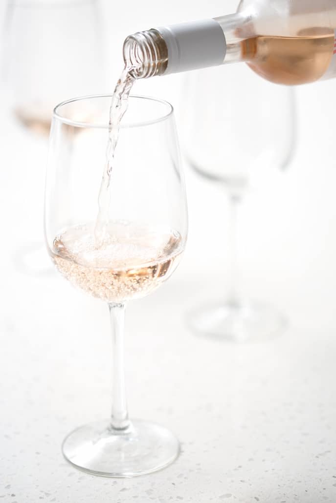 rose wine being poured into wine glass