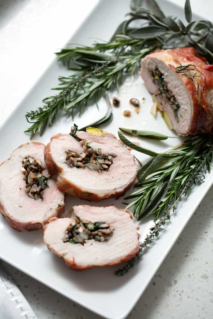 This Prosciutto Wrapped Pork Roast with Brussel Sprouts recipe is pork roast stuffed with savory mushrooms, onions and herbs then wrapped in salty prosciutto and fished off with brussel sprouts. It’s a complete meal in one dish. This recipe is allergy friendly (gluten, dairy, shellfish, nut, egg, and soy free) and suits the AIP and Paleo diets.