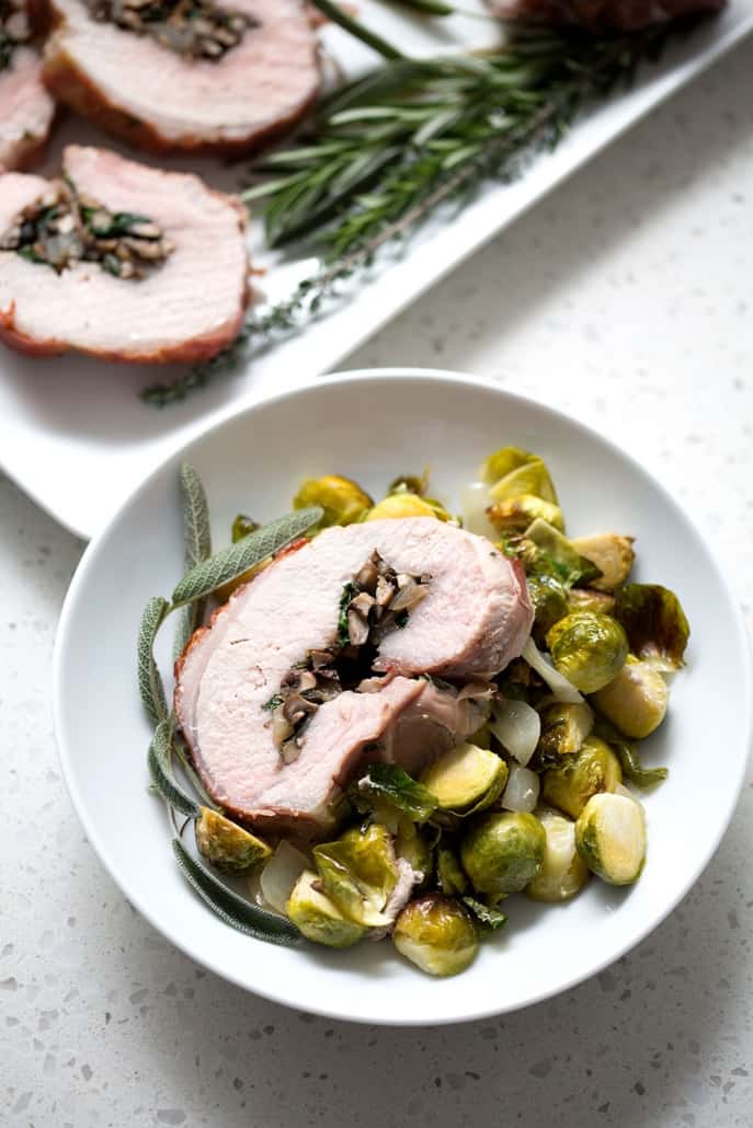 This Prosciutto Wrapped Pork Roast with Brussel Sprouts recipe is pork roast stuffed with savory mushrooms, onions and herbs then wrapped in salty prosciutto and fished off with brussel sprouts. It’s a complete meal in one dish. This recipe is allergy friendly (gluten, dairy, shellfish, nut, egg, and soy free) and suits the AIP and Paleo diets.