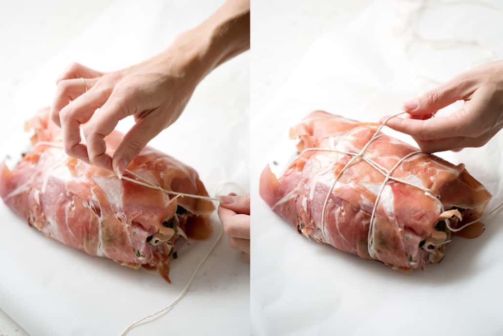 tying string around prosciutto wrapped pork loin on white background