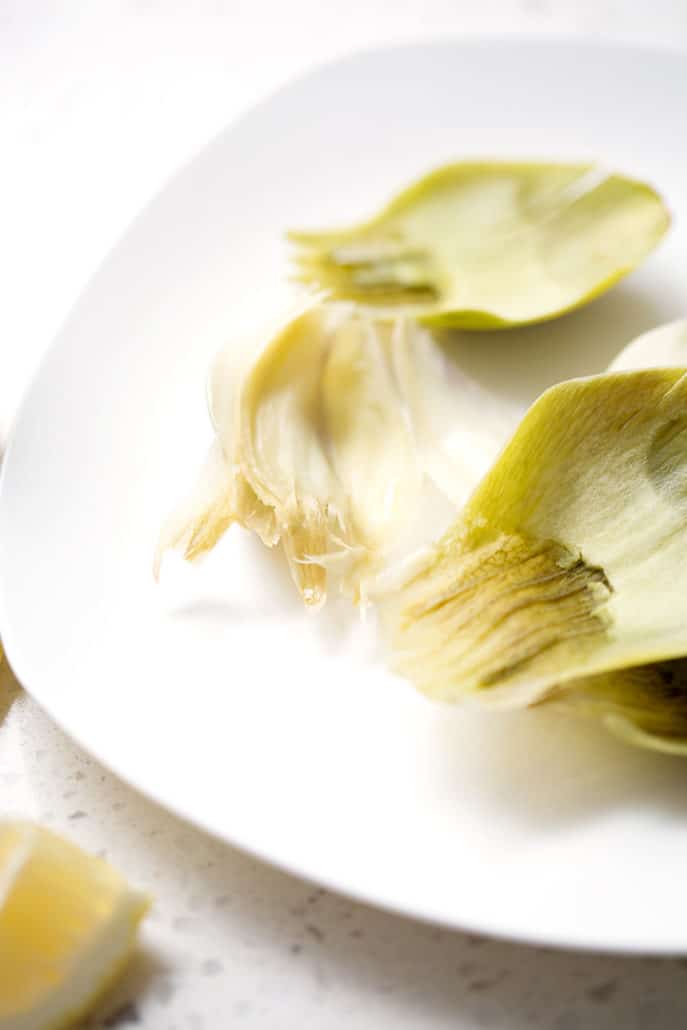 eaten artichoke leafs on white plate