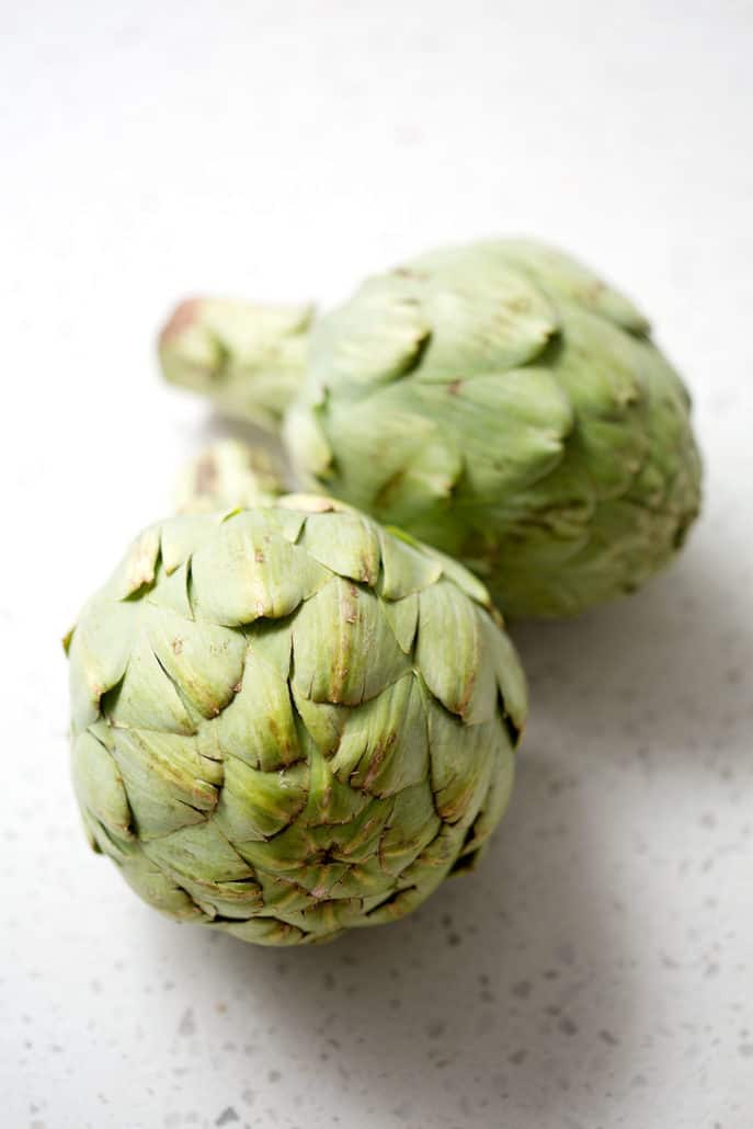 whole artichokes on white counter