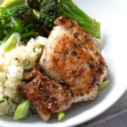 chicken on bed of rice with broccoli in white bowl