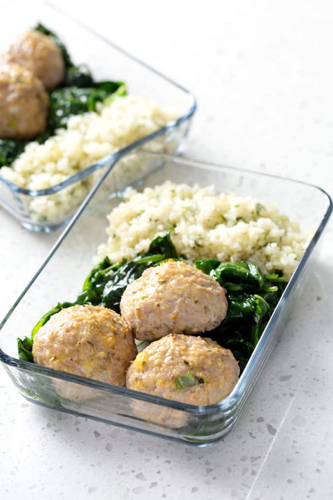 meatballs, spinach and rice in glass dish on white counter