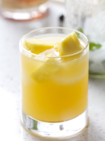 glass filled with juice and pineapple chucks