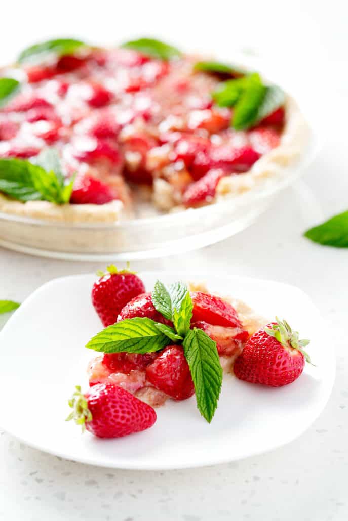 slice of strawberry pie on plate in front of whole pie