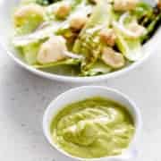 green salad dressing next to salad bowl