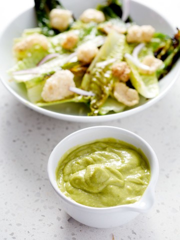 green salad dressing next to salad bowl