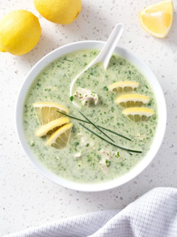 bowl of green soup with lemon and chive garnish from above