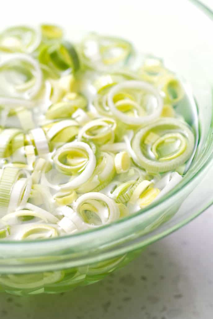 close up of sliced leeks on bowl of water