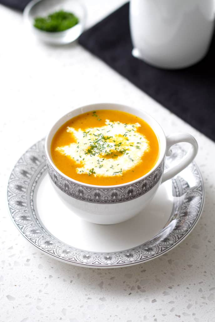 cup of soup with cream on whitecountertop