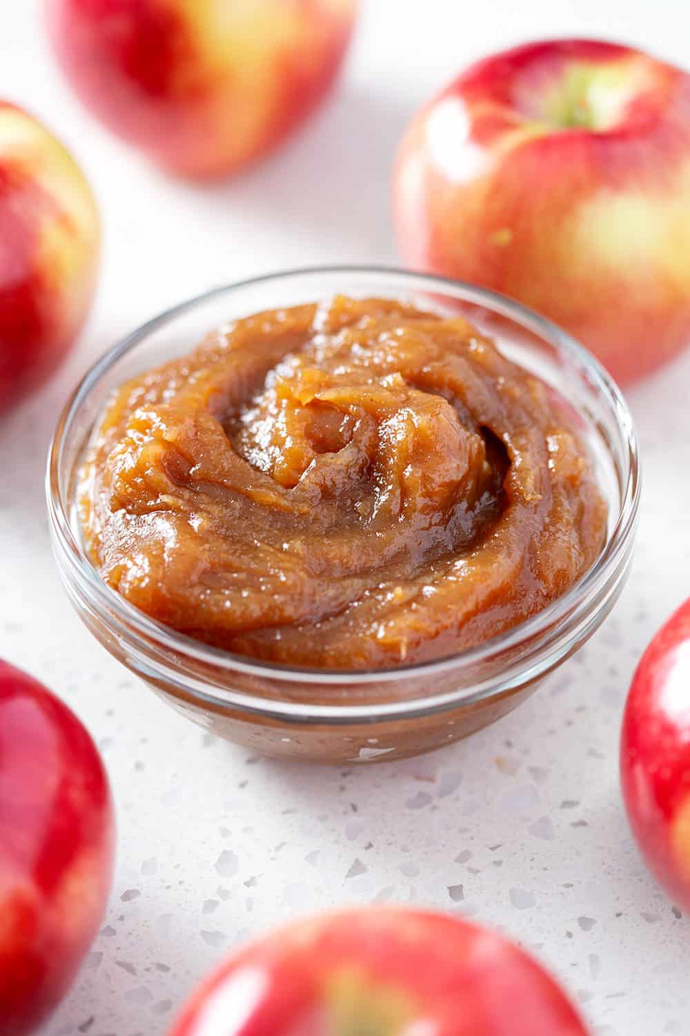 bowl of instant pot apple butter surrounded by apples