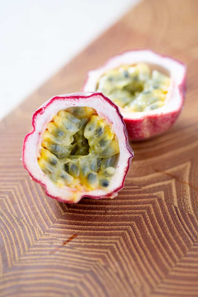 passion fruit cut in half on cutting board exposing fruit