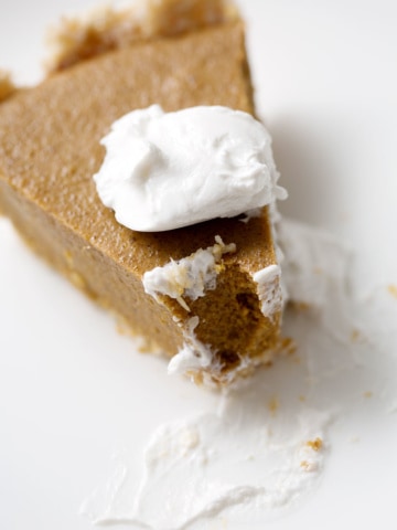 piece of pumpkin pie with dollop of cream close up