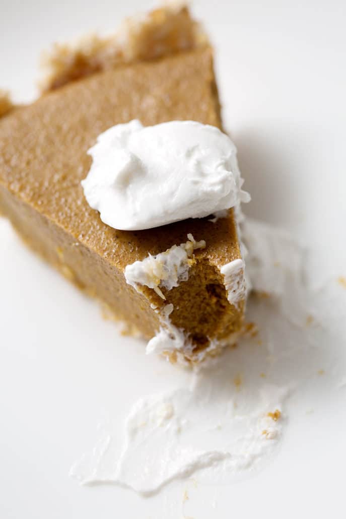 slice of pumpkin pie with dollop of cream on top