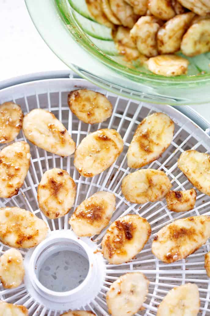 banana slices in bowl and on dehydrator trays