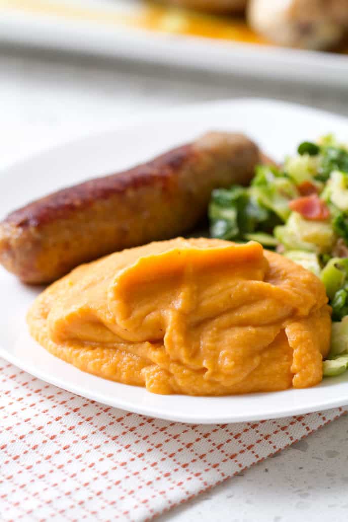 plate of mashed sweet potatoes, sausage and greens
