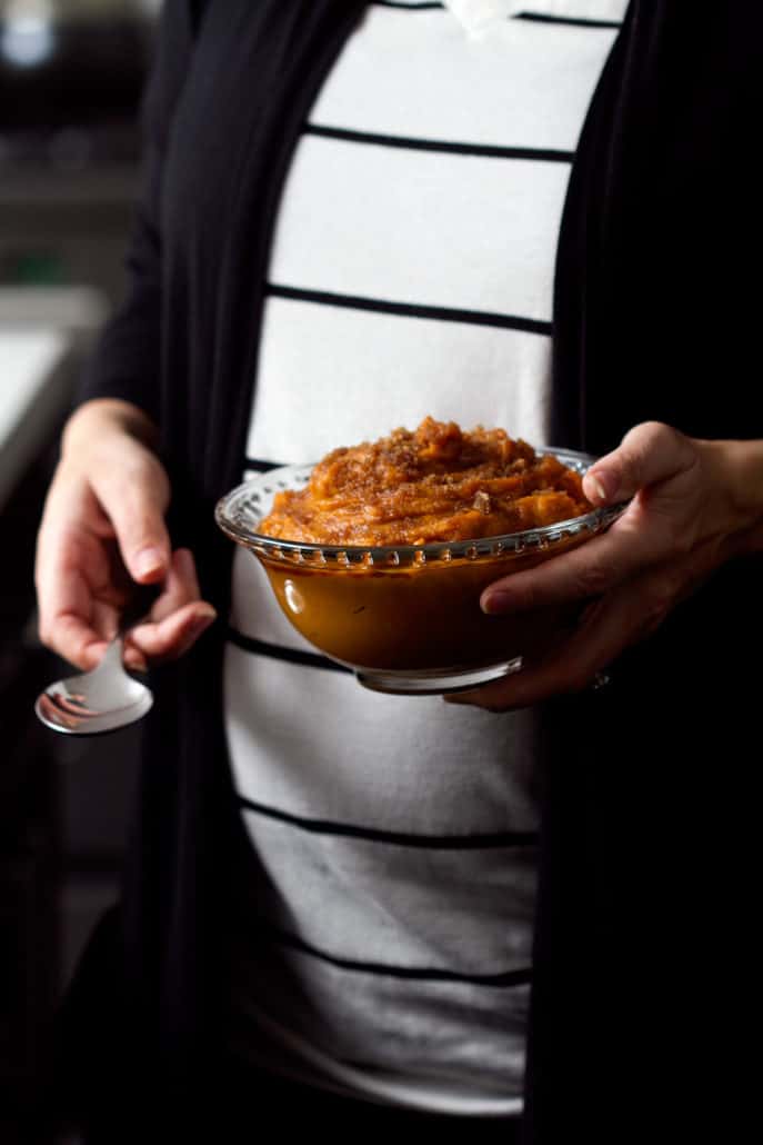 close up of pregnant women holding mashed sweet potatoes