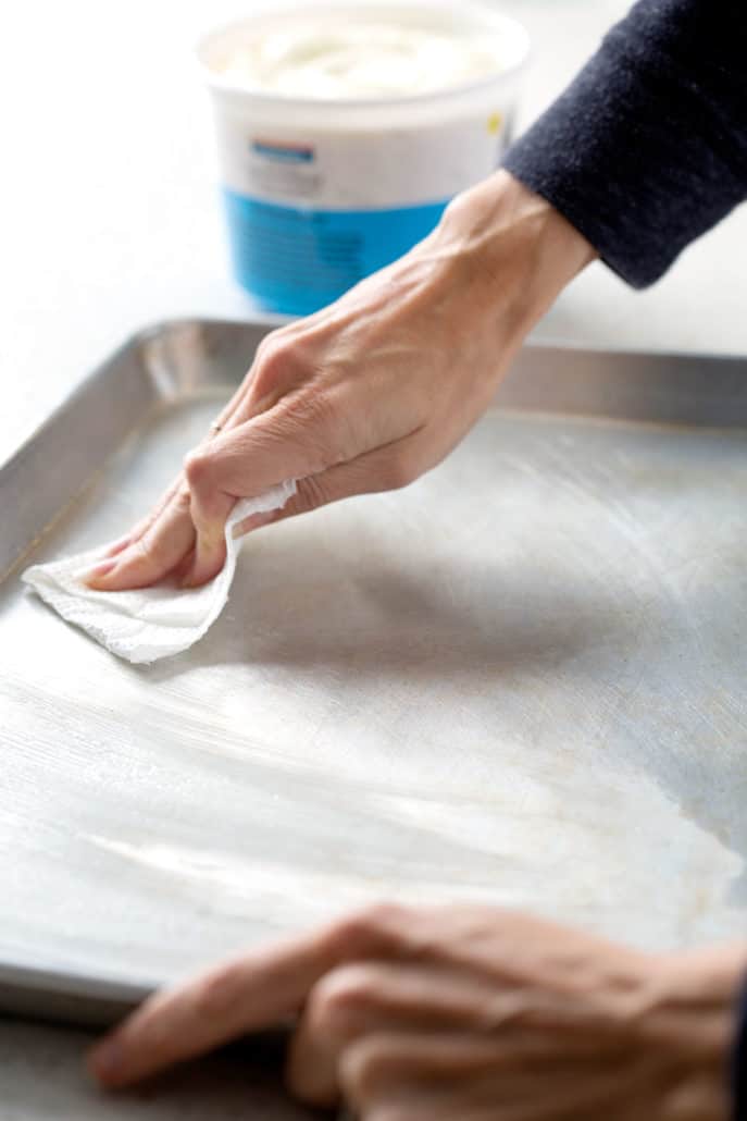 rubbing shortening onto baking sheet