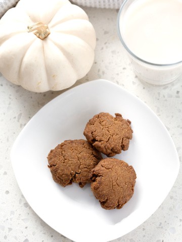 aip ginger cookies surrounded by pumpkin and glass of milk