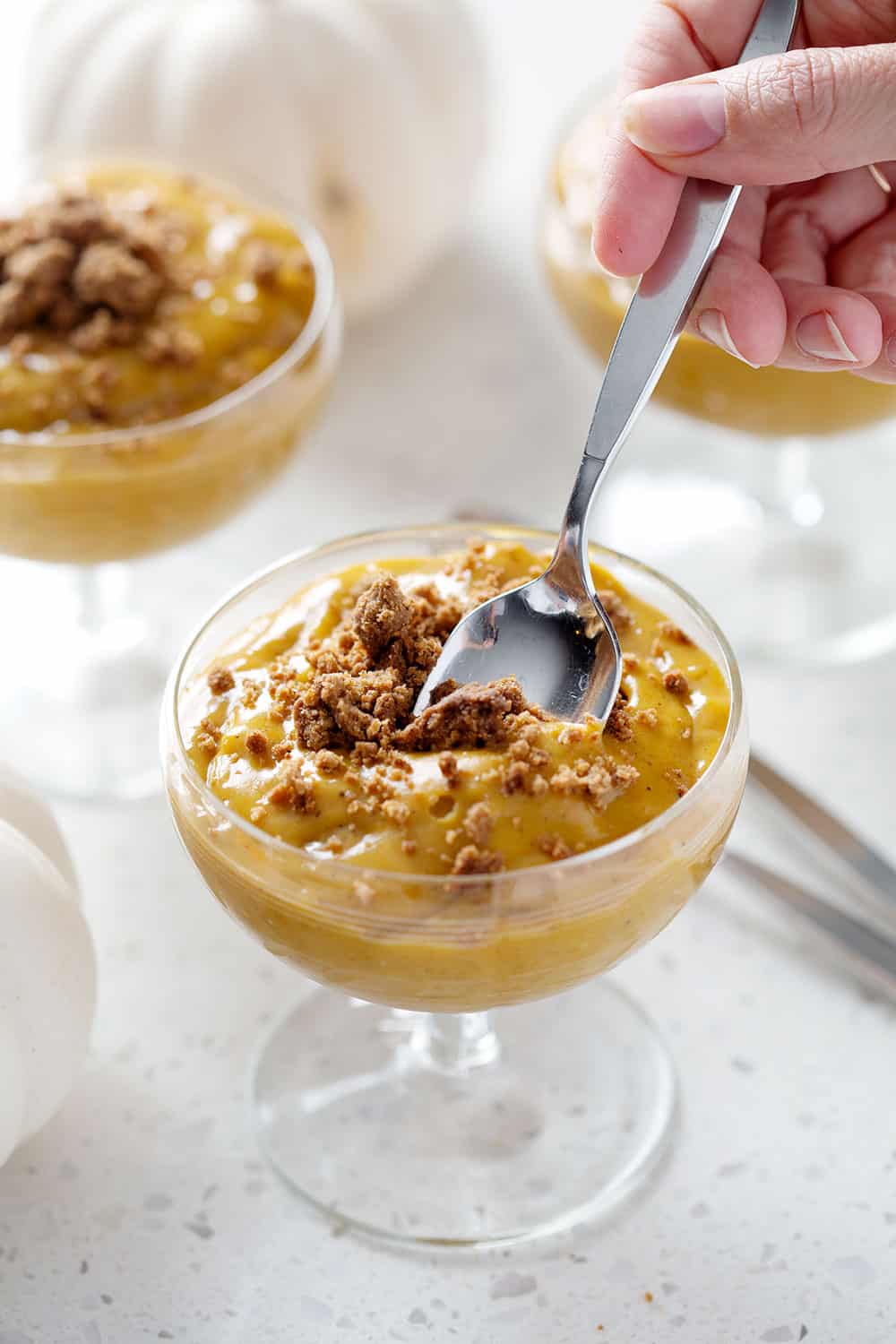 taking a spoonful of aip pumpkin pudding from cup
