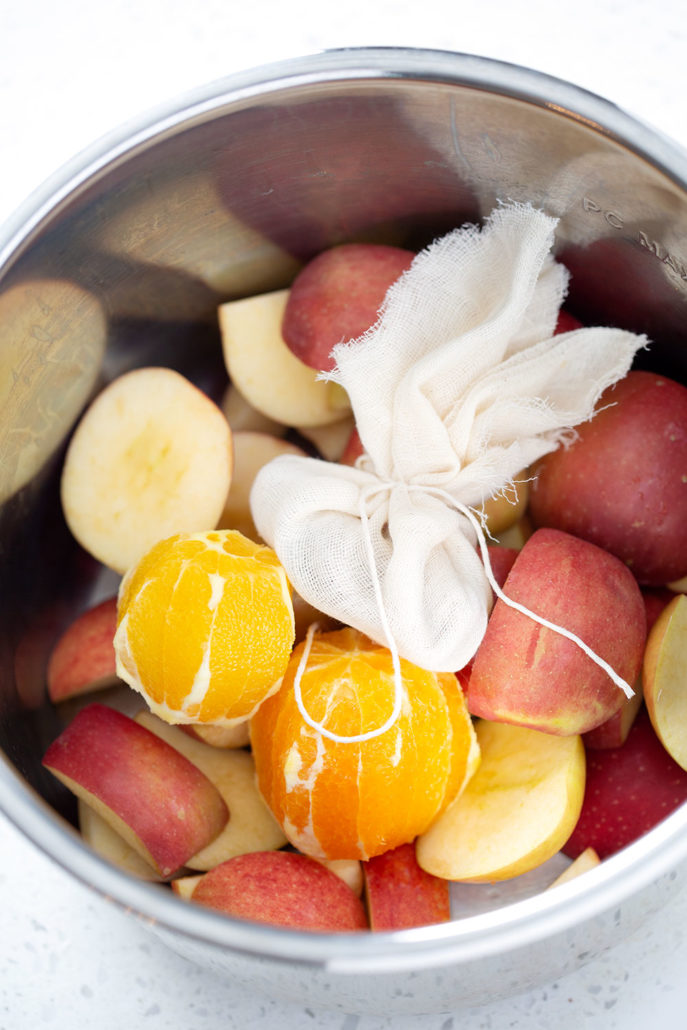 cut apples, oranges and spice sachet in instant pot