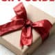package with red bow and words holiday gift guide for aip lifestyle