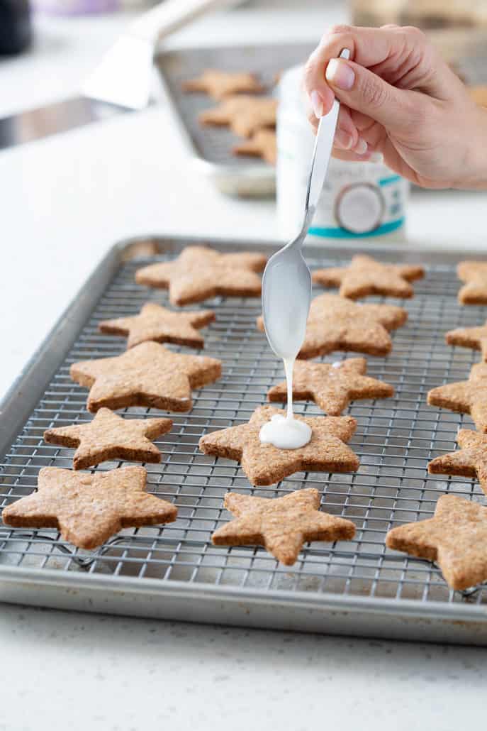 drizzling frosting onto star cookies