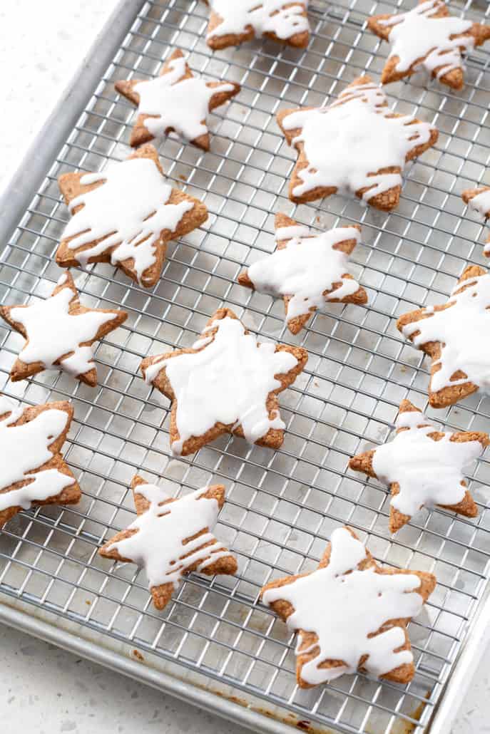 frosted star cookies on wire rack on baking sheet