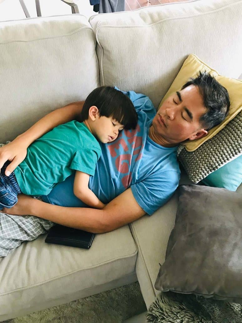 father and son sleeping on couch