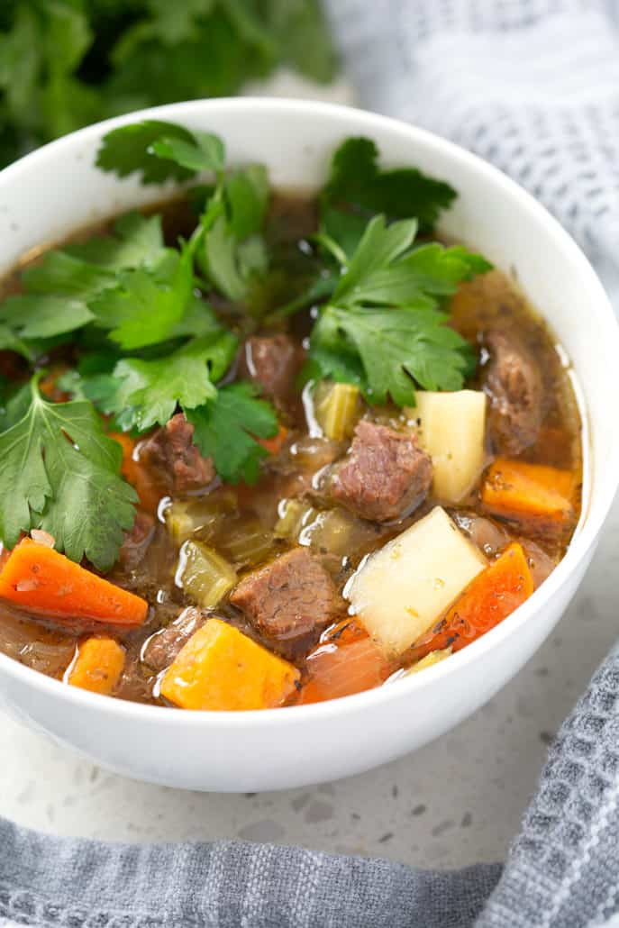 close up of bowl aip beef stew with parsley garnish