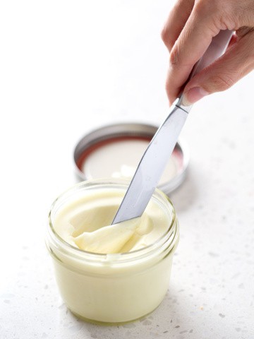 mason jar filled with egg free mayo with knife scooping it out