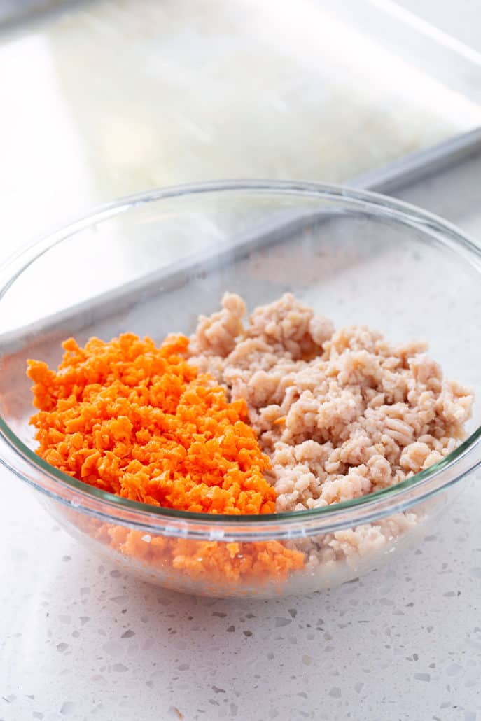 Ground chicken and riced sweet potatoes in glass bowl