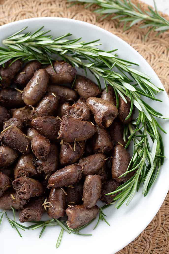 plate of rosemary chicken hearts garnished with fresh rosemary