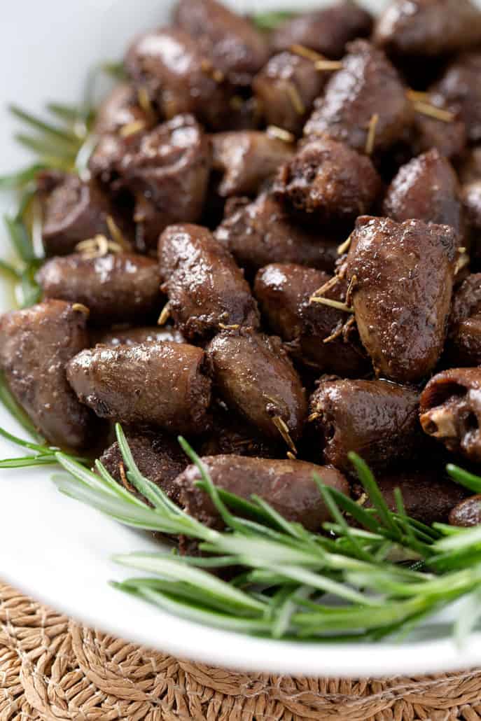 close up of chicken hearts garnished by fresh rosemary