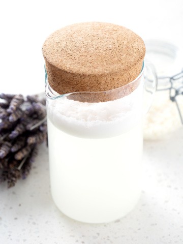pitcher of Homemade Laundry Detergent with Castile Bar Soap on white background