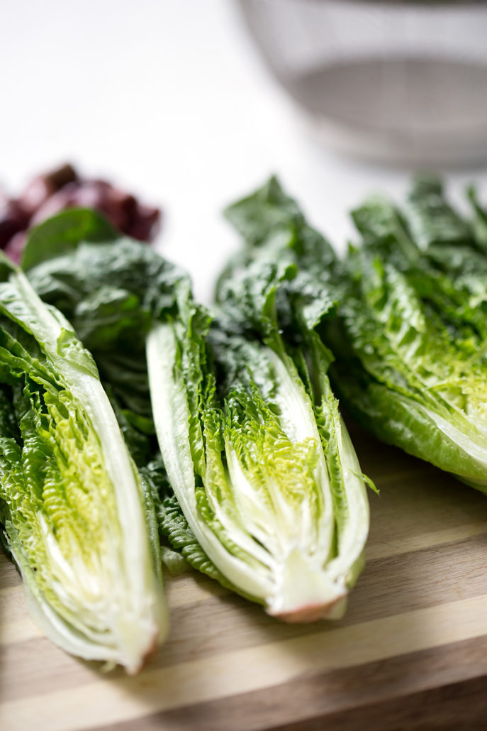 romaine lettuce cut in half on cutting board