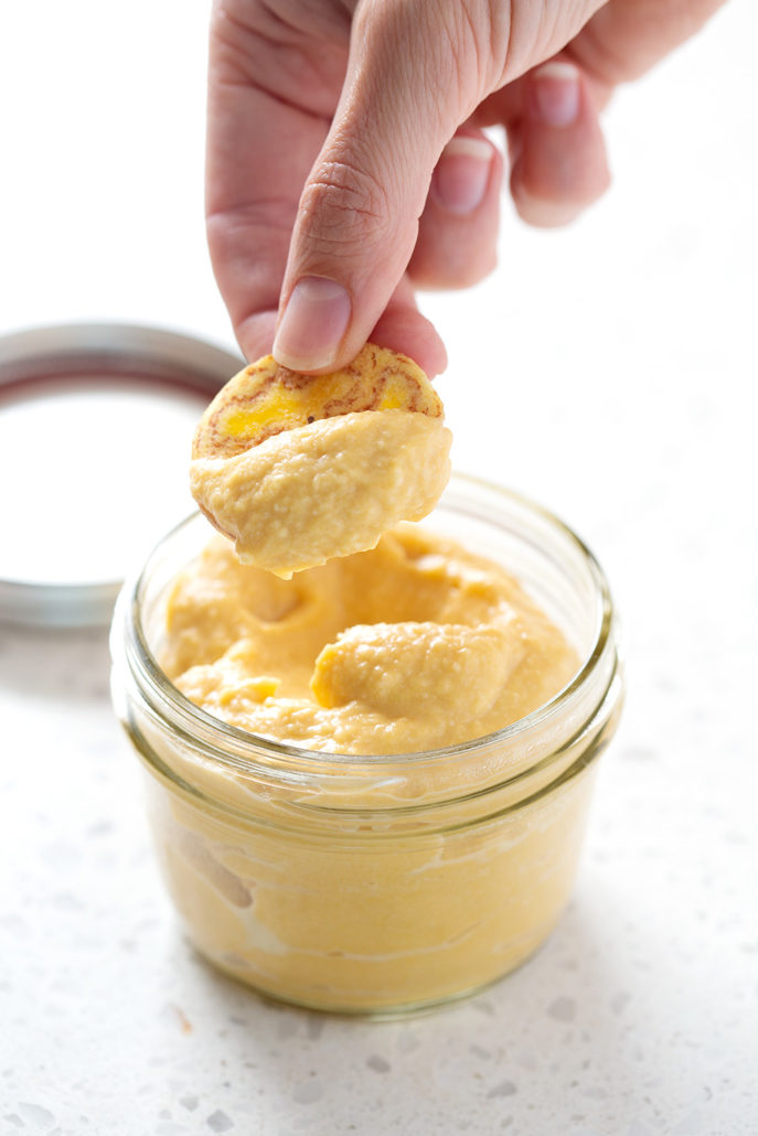 dipping chip into AIP Nacho 'Cheese' Sauce
