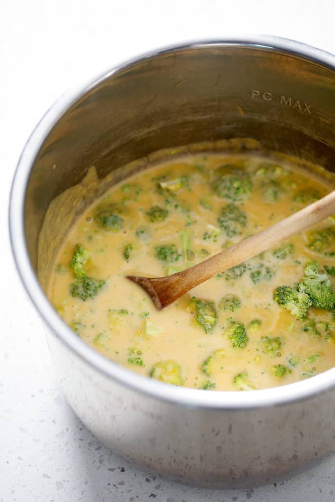 AIP broccoli cheese soup in instant pot with wooden spoon