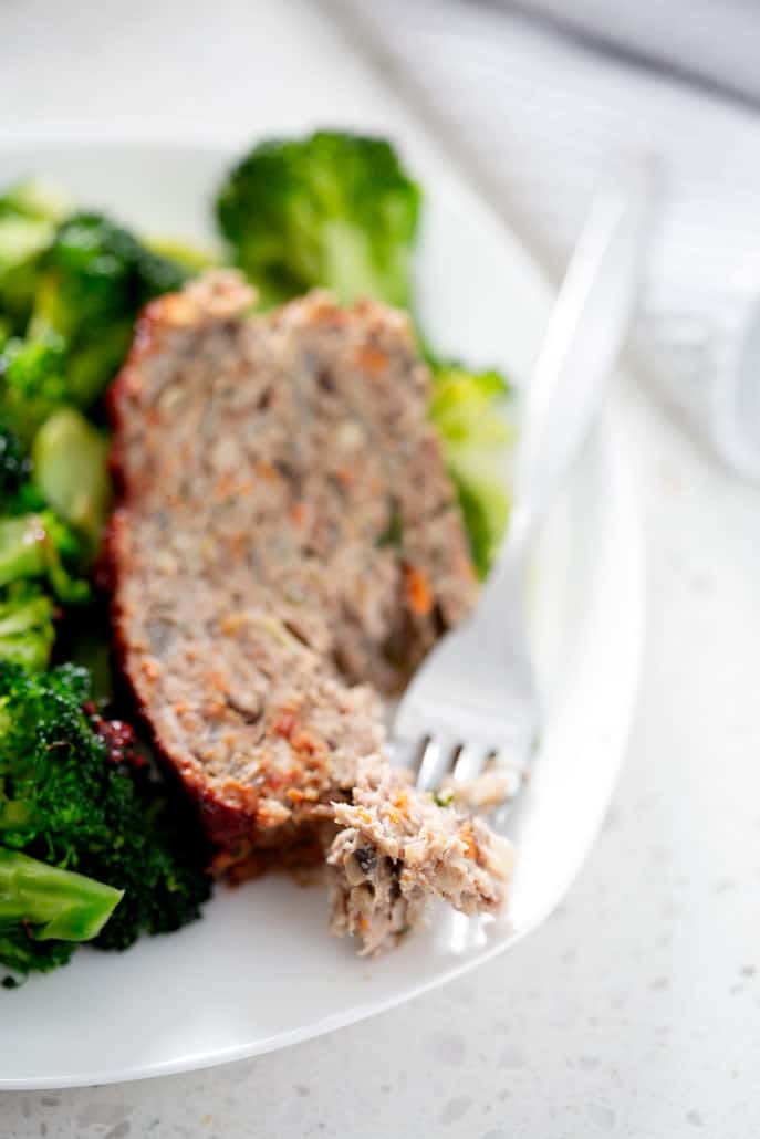 close up of meatloaf and fork with broccoli