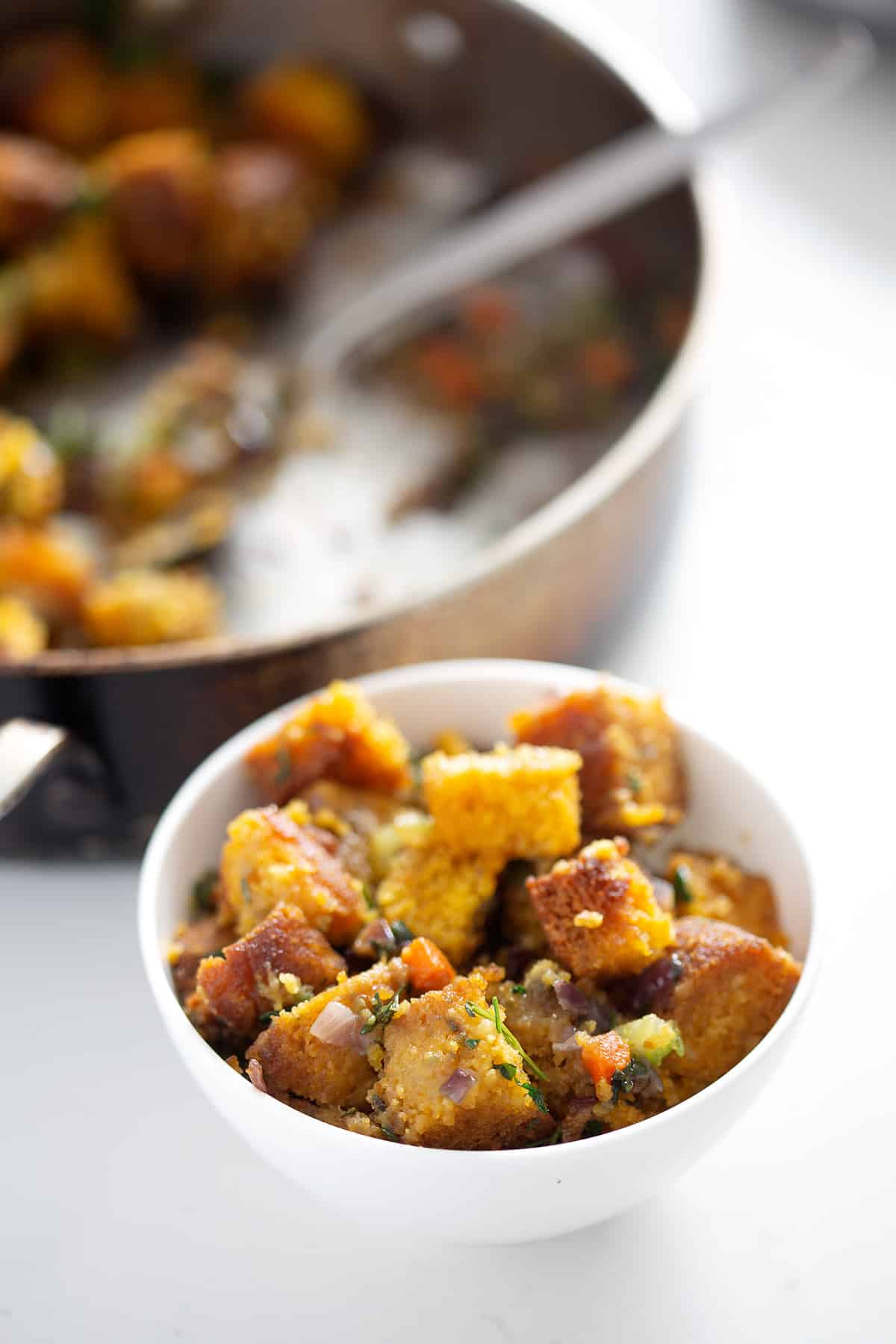 bowl of Gluten Free 'Cornbread' Stuffing with pan in background