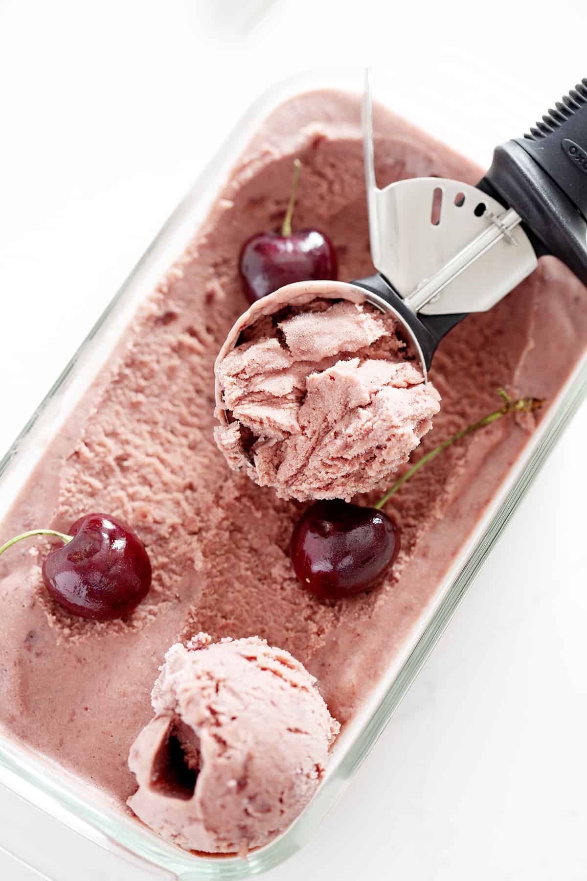 ice cream scoop in container of AIP Ice Cream with black cherries