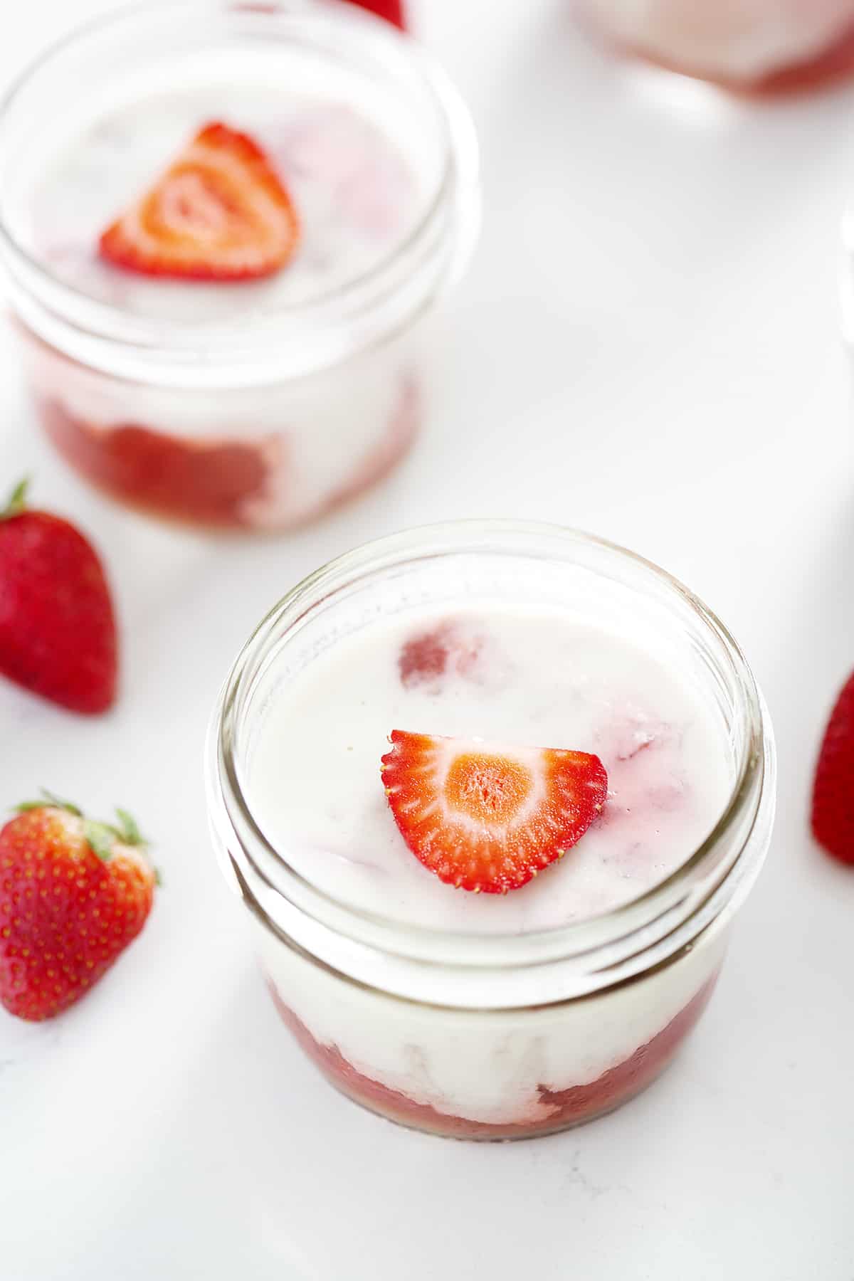 mason jars of panna cotta with coconut milk with strawberries